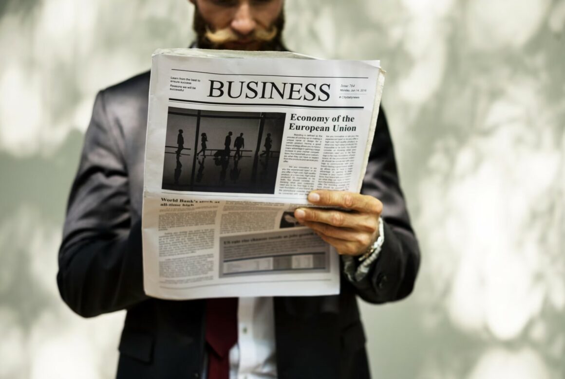 Businessman standing and reading newspaper