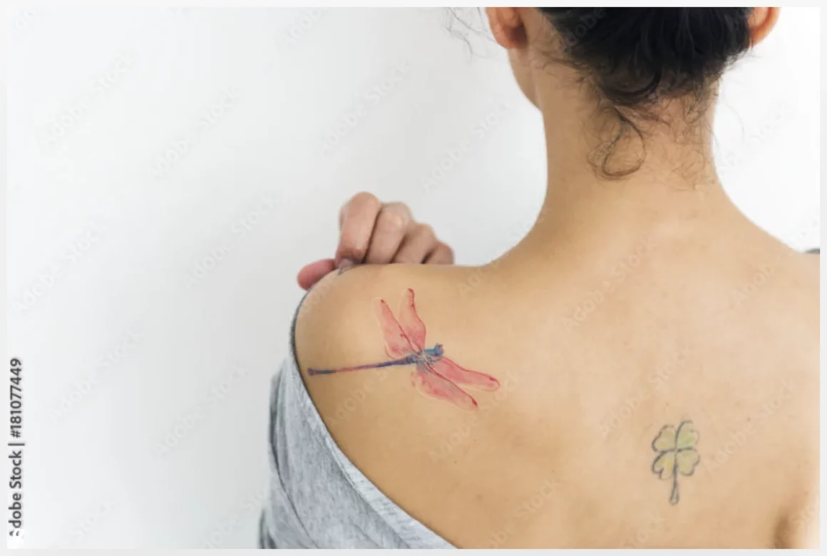 A woman is showing her tattoo on her back